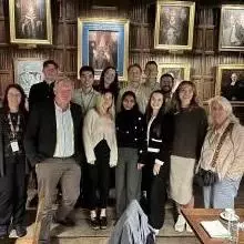 group photo in front of old paintings