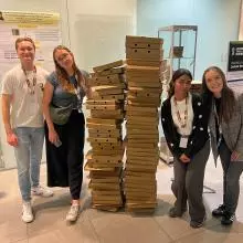 Four members of the Preston lab stand either side of two head high pizza box stacks at the end of the ECPP24 reception in September 2024
